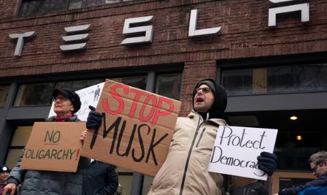 “Demonstrators Rally at Tesla Showrooms Across the US to Protest Elon Musk’s Role in Government Budget Cuts”